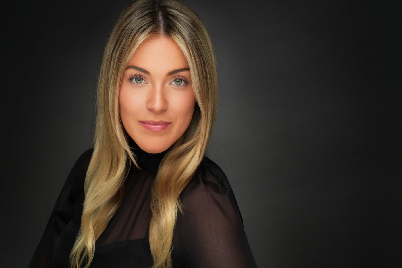 Studio headshot photographed on a dark background