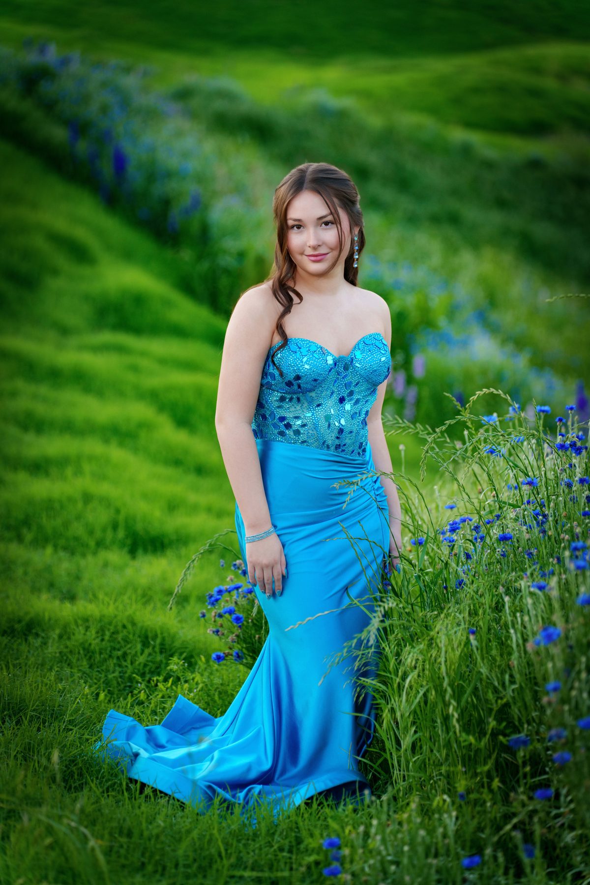 Senior in a formal blue dress in a wildflower field